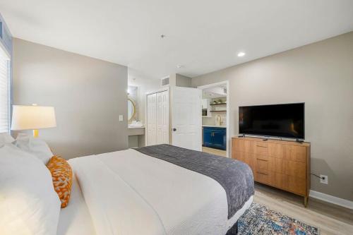 a bedroom with a large bed and a flat screen tv at Modern Urban Oasis in Prime Buckhead Atlanta in Atlanta
