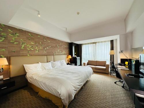 Holiday Inn Xi'an Greenland Century City, an IHG Hotel في شيان: غرفة الفندق بسرير كبير ومكتب