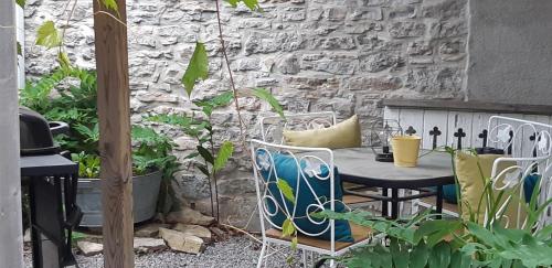 a table and chairs in front of a stone wall at Stone Carriage House in Picton