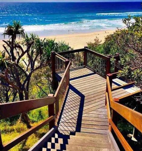 a wooden staircase leading to a beach with the ocean at PA1,Great Holiday in Sunshine Beach with your pets in Sunshine Beach