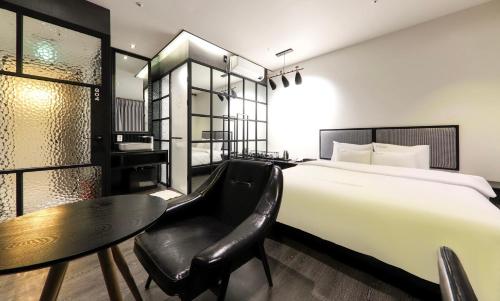 a hotel room with a bed and a table and chair at Den Basta hotel in Yangsan
