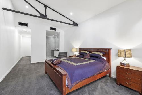 a bedroom with a large bed and a desk at Platinum Precinct - The Penthouse in Newcastle