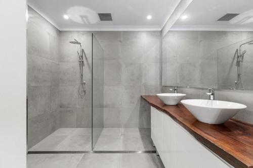 a bathroom with a shower and a sink and a shower stall at Platinum Precinct - The Penthouse in Newcastle