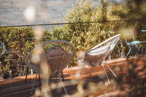 two chairs sitting on a deck on a balcony at Ora Retreat in Queenstown