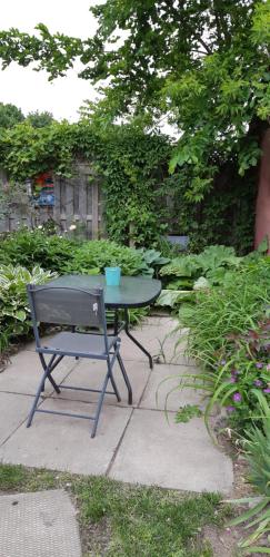 a table and a chair in a garden at Stone Carriage House in Picton