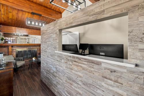 a living room with a stone wall with a tv at Rodeway Inn Dickson in Dickson