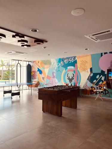 a room with a ping pong table and a mural at Camino al Mar in Mazatlán