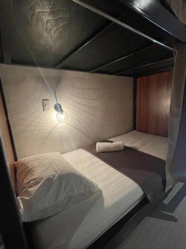 a bedroom with two beds and a light on the wall at The Millas Hostel in Manila