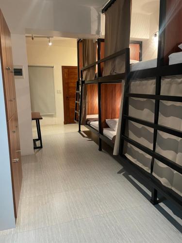 a dorm room with bunk beds and a hallway at The Millas Hostel in Manila