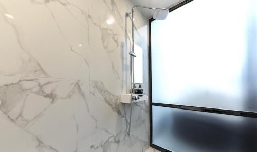 a shower with a glass door in a bathroom at Den Basta hotel in Yangsan