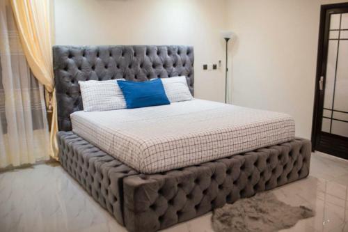 ein großes Bett mit gepolstertem Rahmen in einem Schlafzimmer in der Unterkunft Sleek Luxury Homes in Kumasi