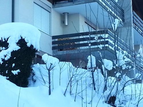 a building with snow on the side of it at Two-bedroom Apartment for 4-5 guests with lake and mountain views in Emmetten