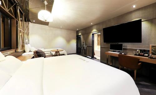 a hotel room with a large bed and a flat screen tv at Den Basta hotel in Yangsan