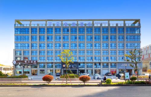 舟山市にあるZhoushan Maison New Century Hotelの都市の青窓のある大きな建物