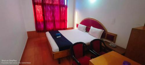 a small bed in a room with a red window at SRIKRUTI SEA VIEW in Puri