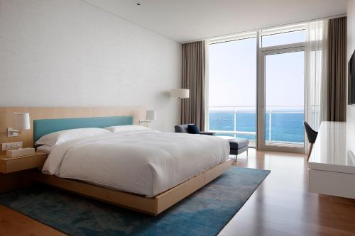 a bedroom with a large bed and a large window at SEAMARQ HOTEL in Gangneung