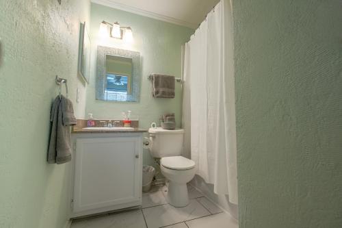 a bathroom with a toilet and a sink and a mirror at Portabella Paradise in Carolina Beach