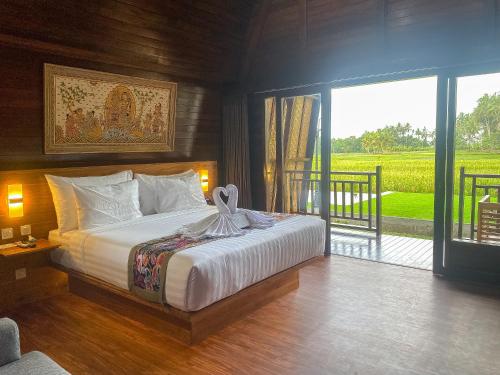 1 dormitorio con 1 cama y balcón con vistas. en Adil Villa & Resort en Ubud