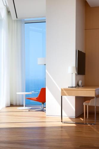 a living room with a table and a red chair at SEAMARQ HOTEL in Gangneung