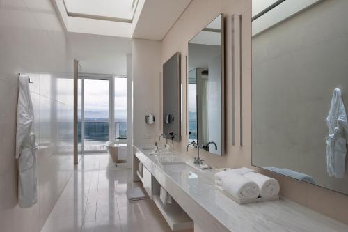 a white bathroom with a sink and a mirror at SEAMARQ HOTEL in Gangneung