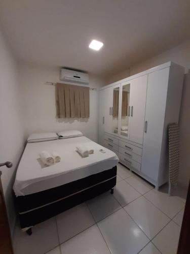 1 dormitorio blanco con 1 cama y armario en Casa Alto da Falésia, en Baía Formosa