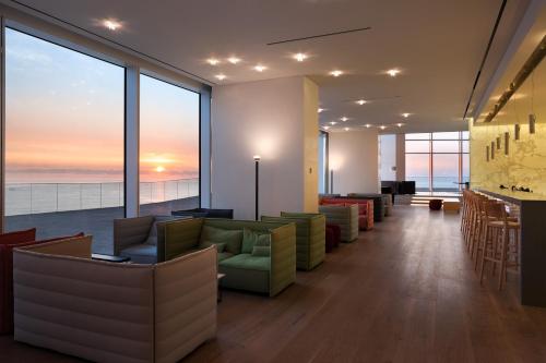 a lobby with couches and a bar with a view at SEAMARQ HOTEL in Gangneung