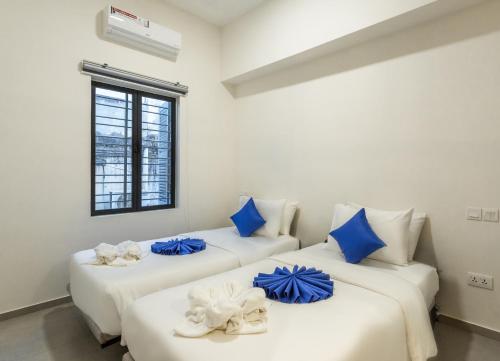 2 Betten in einem Zimmer mit blauen Kissen darauf in der Unterkunft Family Style 3-Bedroom Suite by Baahu Villa in Siem Reap