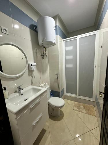 La salle de bains est pourvue de toilettes, d'un lavabo et d'un miroir. dans l'établissement Joli Studio vue sur Mer - Gare TGV, à Tanger