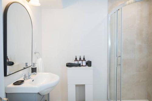 a white bathroom with a sink and a shower at The Oasis in Bowmanville