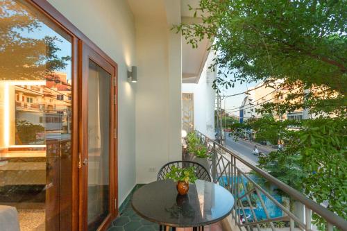 a glass table on a balcony with a view of a street at Family Style 3-Bedroom Suite by Baahu Villa in Siem Reap