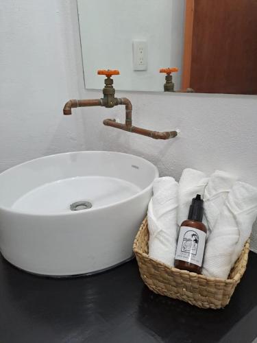 a bathroom sink with a basket of towels next to it at Casa Baloo in El Cuyo