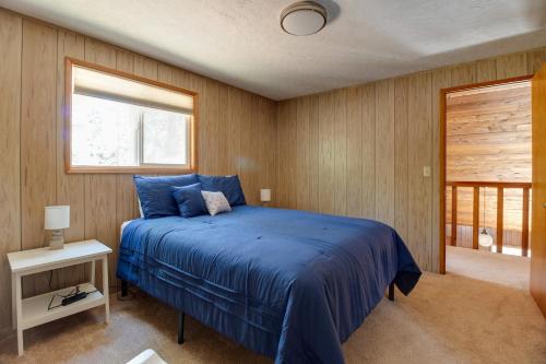 Un dormitorio con una cama azul y una ventana. en Peters Cabin, en Sisters
