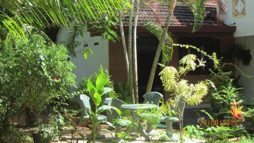 a garden with chairs in front of a building at Solal Villa in Aluthgama