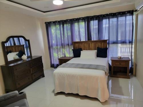 ein Schlafzimmer mit einem Bett und einem großen Fenster in der Unterkunft D'Rhatid Mansion in Saint Mary