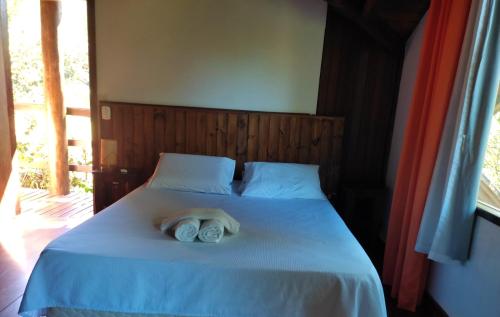 a bed with two rolled towels on top of it at Pássaro de Fogo in Santo Antônio do Pinhal