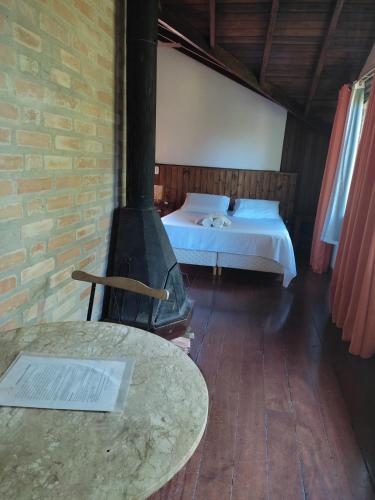 a bedroom with a bed and a stove in a room at Pássaro de Fogo in Santo Antônio do Pinhal