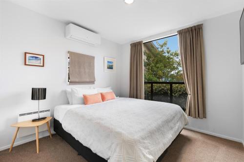 um quarto com uma cama grande e uma janela em The Twins em Queenstown
