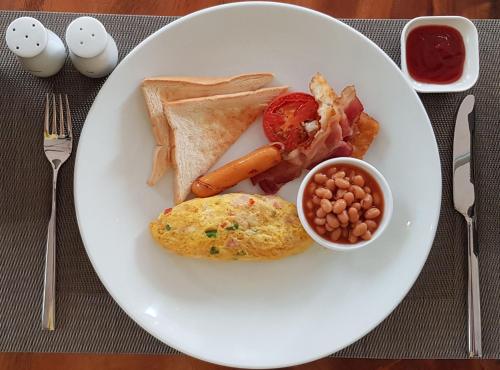 a plate of breakfast food with ham eggs beans and toast at Family Style 3-Bedroom Suite by Baahu Villa in Siem Reap