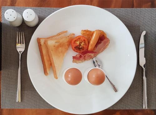 a plate of food with eggs and ham and toast at Family Style 3-Bedroom Suite by Baahu Villa in Siem Reap