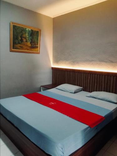 een bed in een kamer met een rode deken erop bij TW penginapan in Cianjur