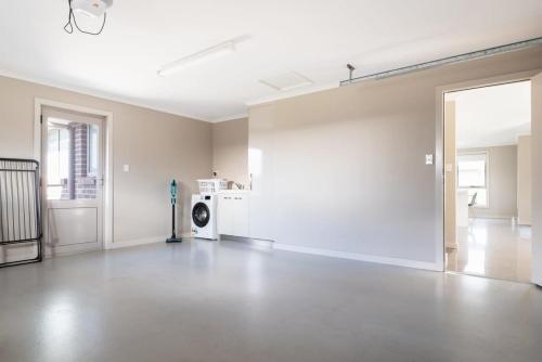 an empty living room with a washer and dryer at Cute and Cosy 2 Bedroom Unit with Parking and WiFi in Kings Meadows