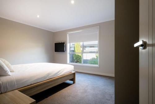 a bedroom with a bed and a window at Cute and Cosy 2 Bedroom Unit with Parking and WiFi in Kings Meadows