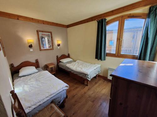 une petite chambre avec deux lits et une table dans l'établissement Chalet confortable à Val Thorens, 50m des pistes, 8 pers., cheminée, parking, local à skis - FR-1-637-80, à Val Thorens