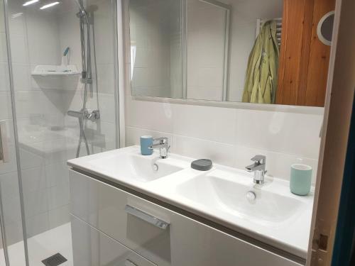 une salle de bain blanche avec un lavabo et un miroir dans l'établissement Maison rénovée avec jardin, proche plage et commerces – Capacité 6 personnes - FR-1-323-511, à Saint-Hilaire-de-Riez