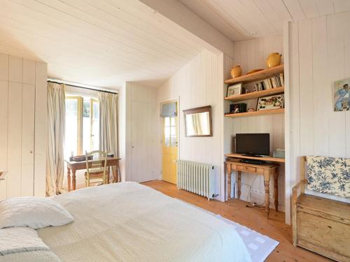 une chambre avec un lit, un bureau et une télévision dans l'établissement Maison de charme aux Portes-en-Ré avec jardin, proche plages et commerces - FR-1-434-110, aux Portes