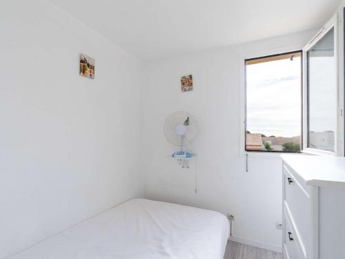 une chambre blanche avec un lit et une fenêtre dans l'établissement Appartement T2 avec piscine, tennis, parking, animaux acceptés - FR-1-409-253, à Fleury