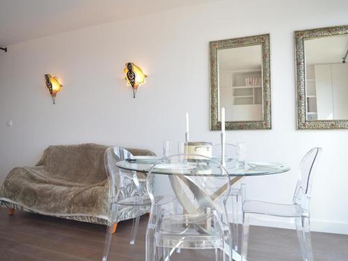 une salle à manger avec une table et des chaises en verre dans l'établissement Appartement moderne 4 pers avec vue mer, parking, lave-vaisselle et lave-linge - FR-1-225C-137, à Banyuls-sur-Mer