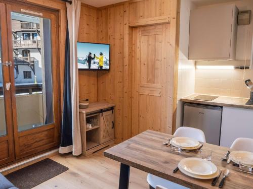 - une cuisine avec une table et une télévision dans la chambre dans l'établissement Appartement Moderne à Val Thorens - 4 pers, 1 Chambre + Cabine, Balcon Sud, Ski aux Pieds - FR-1-637-74, à Val Thorens