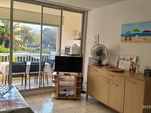 d'un salon avec un bureau, une télévision et un balcon. dans l'établissement Appartement 2 Pièces 6 Pers à 400m de la Plage avec Parking - FR-1-776-74, à Argelès-sur-Mer