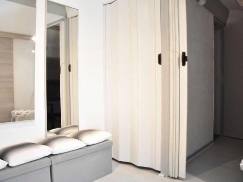 une pièce avec un miroir et un banc avec des coussins dans l'établissement Maison familiale climatisée 4 pièces, 6 couchages, à 100m de la plage - Gruissan Les Ayguades - FR-1-229-878, à Gruissan